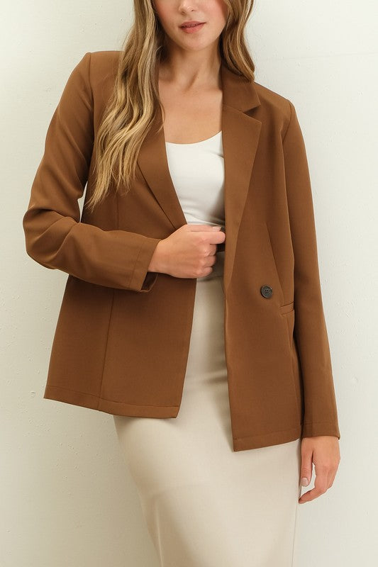 Woman wearing a brown shoulder pad double-breasted blazer with a structured, elegant fit.