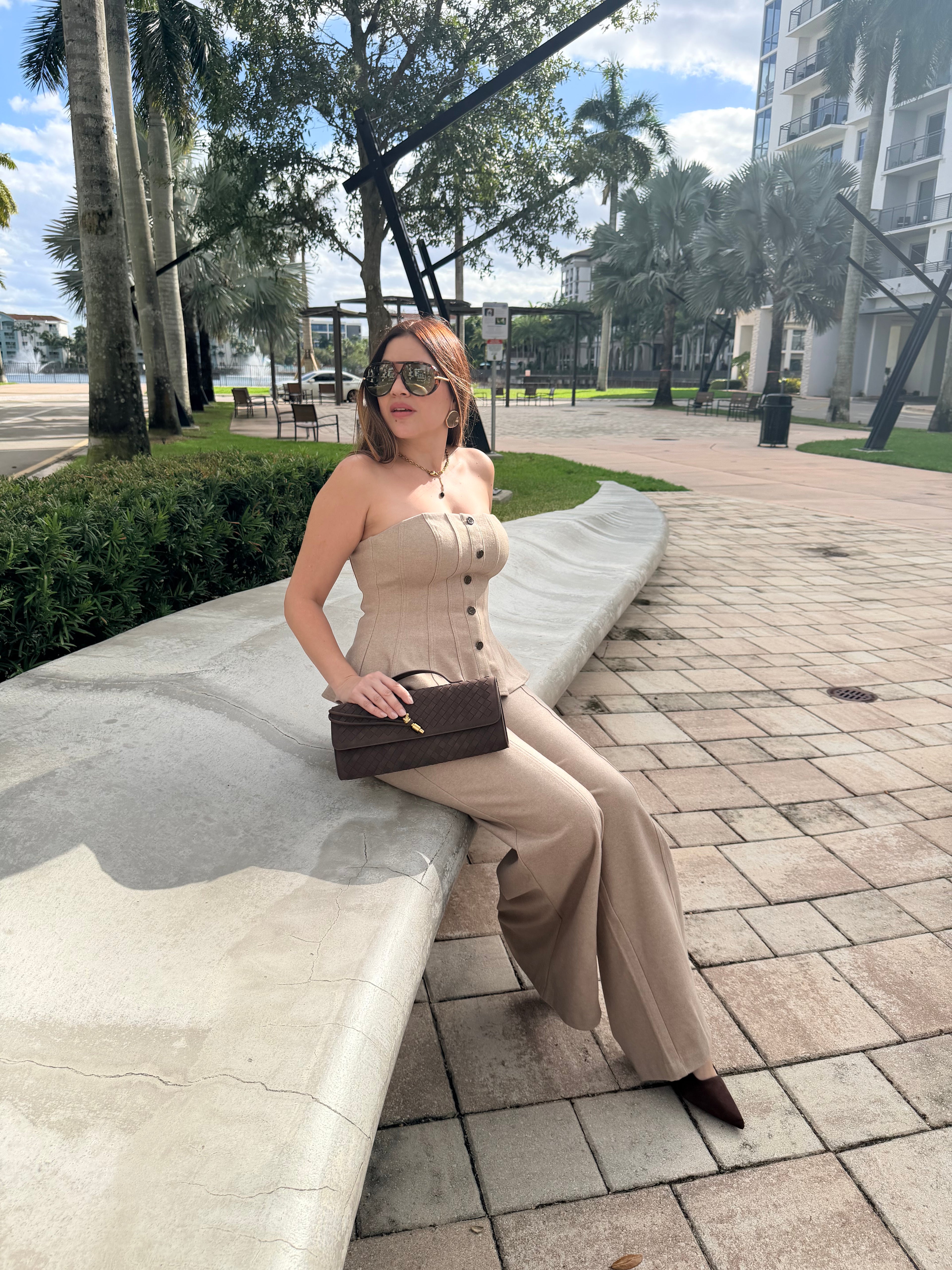 Woman wearing a knit strapless top and wide-leg pants set in a modern neutral tone, styled for effortless elegance.