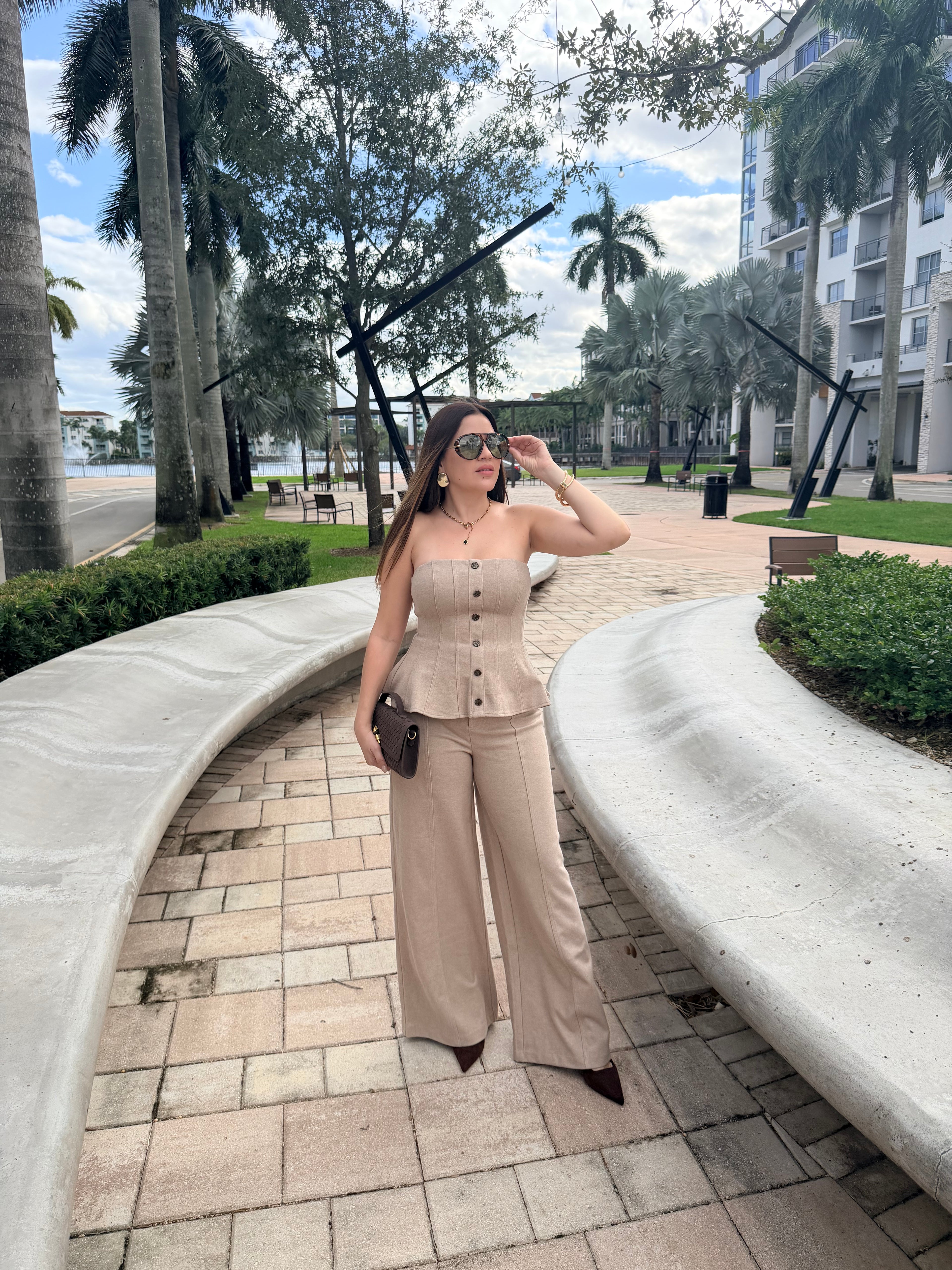 Woman wearing a knit strapless top and wide-leg pants set in a modern neutral tone, styled for effortless elegance.