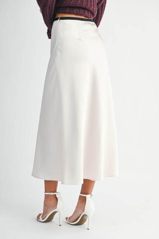 Woman wearing a satin slip midi skirt with a contrast waistband, styled for an elegant and modern day-to-night look.