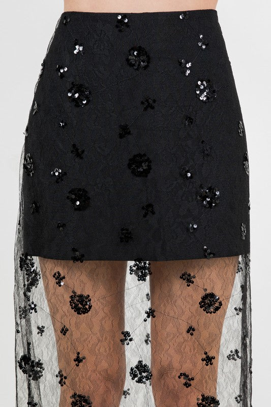 Woman wearing a semi-sheer sequin lace midi skirt with delicate lace detailing, styled for an elegant evening or special occasion.